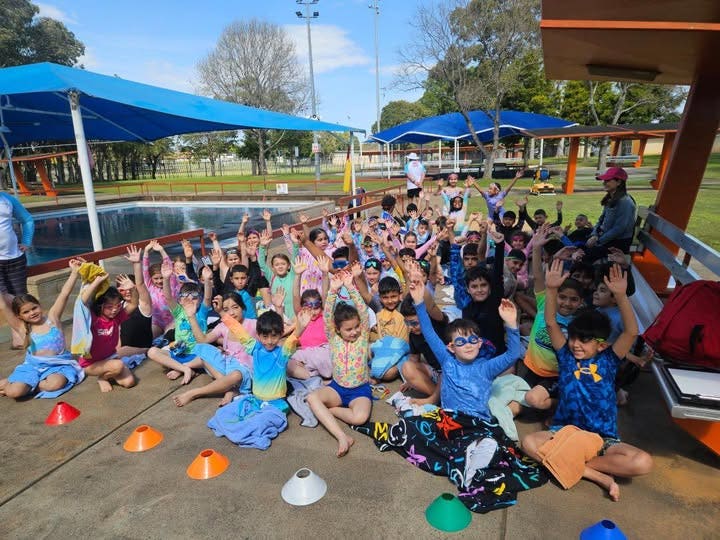 May be an image of 2 people and people swimming